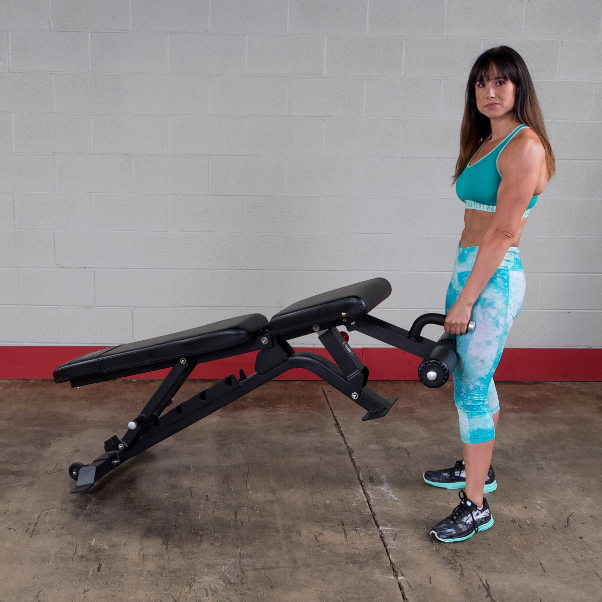 Woman moving a Body-Solid SFID425 Pro ClubLine Flat Incline Decline Bench
