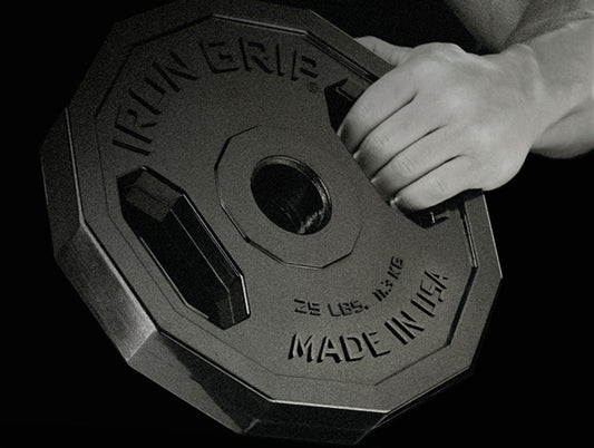 Man gripping Iron Grip Urethane Encased Olympic Plate.