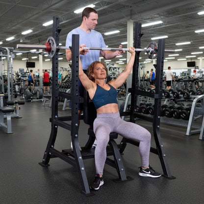 Body-Solid SOSB250 Pro ClubLine Olympic Shoulder Press Bench woman doing a shoulder press with a man spotter
