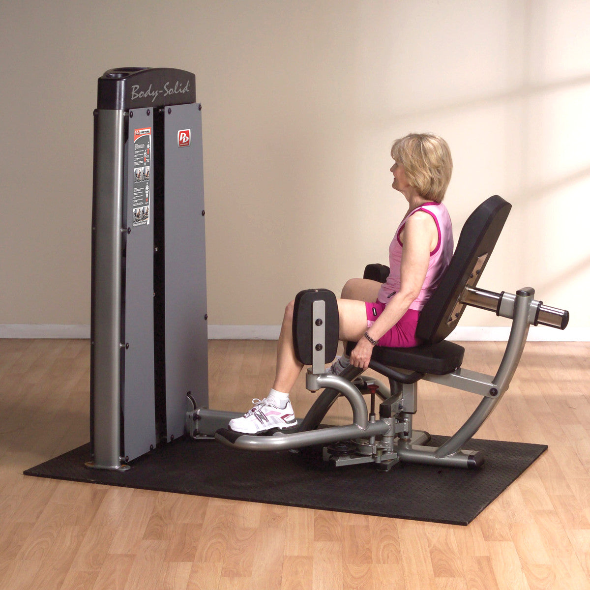 Body-Solid DIOTSF ProDual Inner Outer Thigh Machine in room with woman exercising