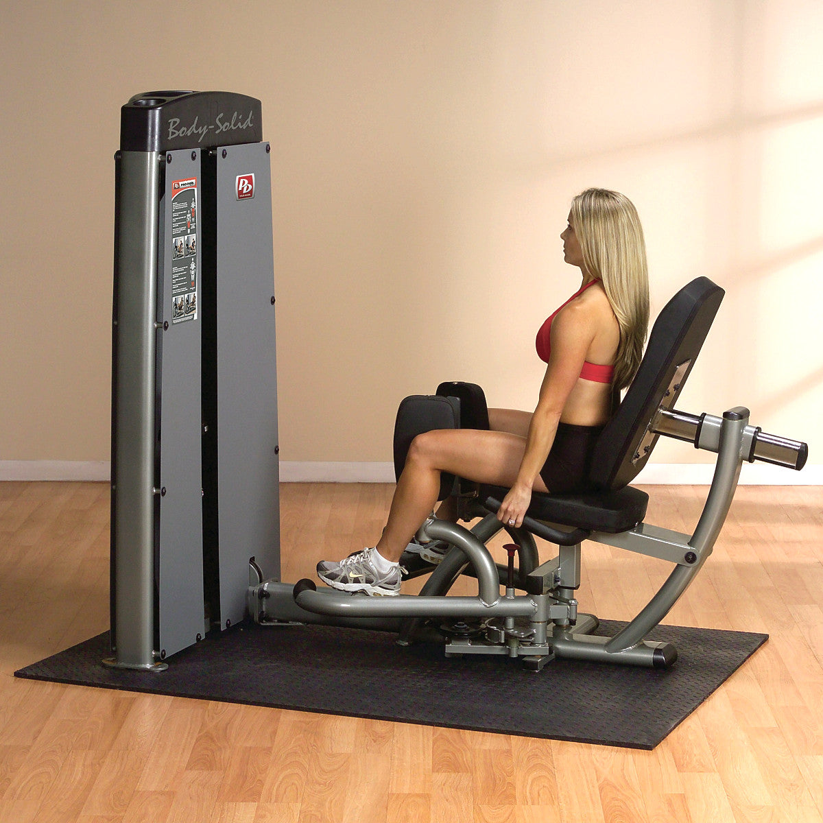 Body-Solid DIOTSF ProDual Inner Outer Thigh Machine in room with woman exercising