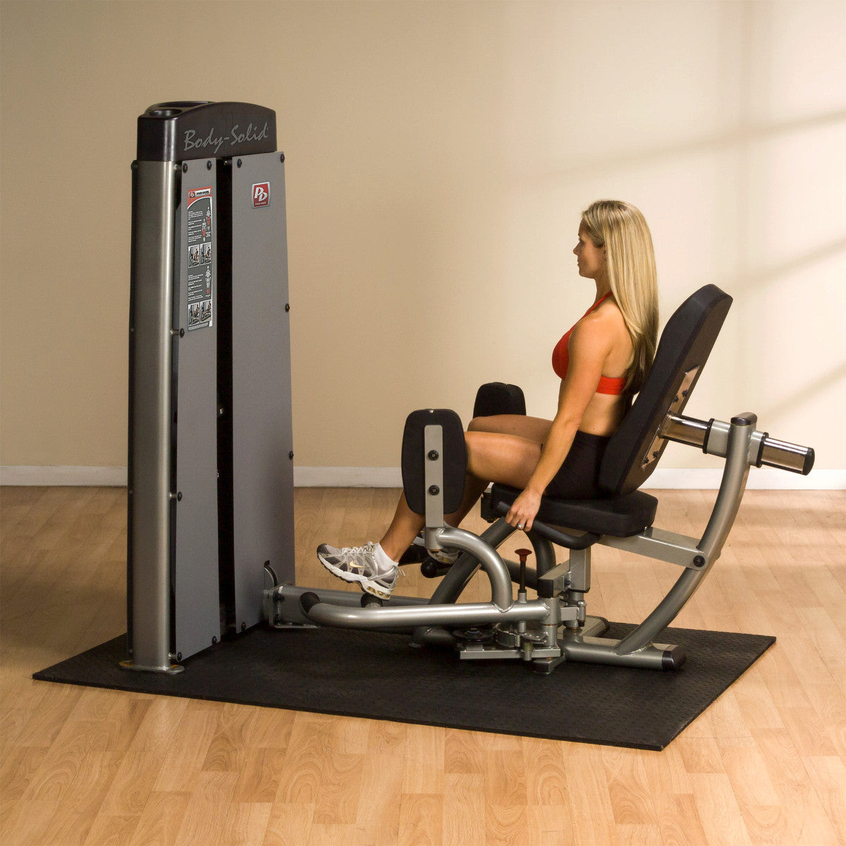 Body-Solid DIOTSF ProDual Inner Outer Thigh Machine in room with woman exercising