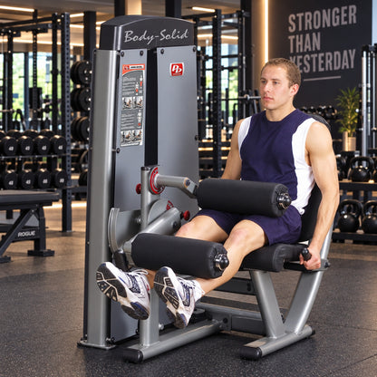 Body-Solid DLECSF ProDual Leg Extension Curl Machine in gym man exercising
