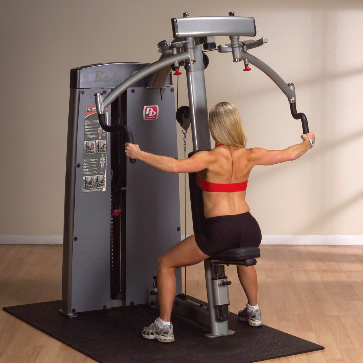 Body-Solid DPECSF ProDual Pec Rear Delt Machine in gym woman exercising