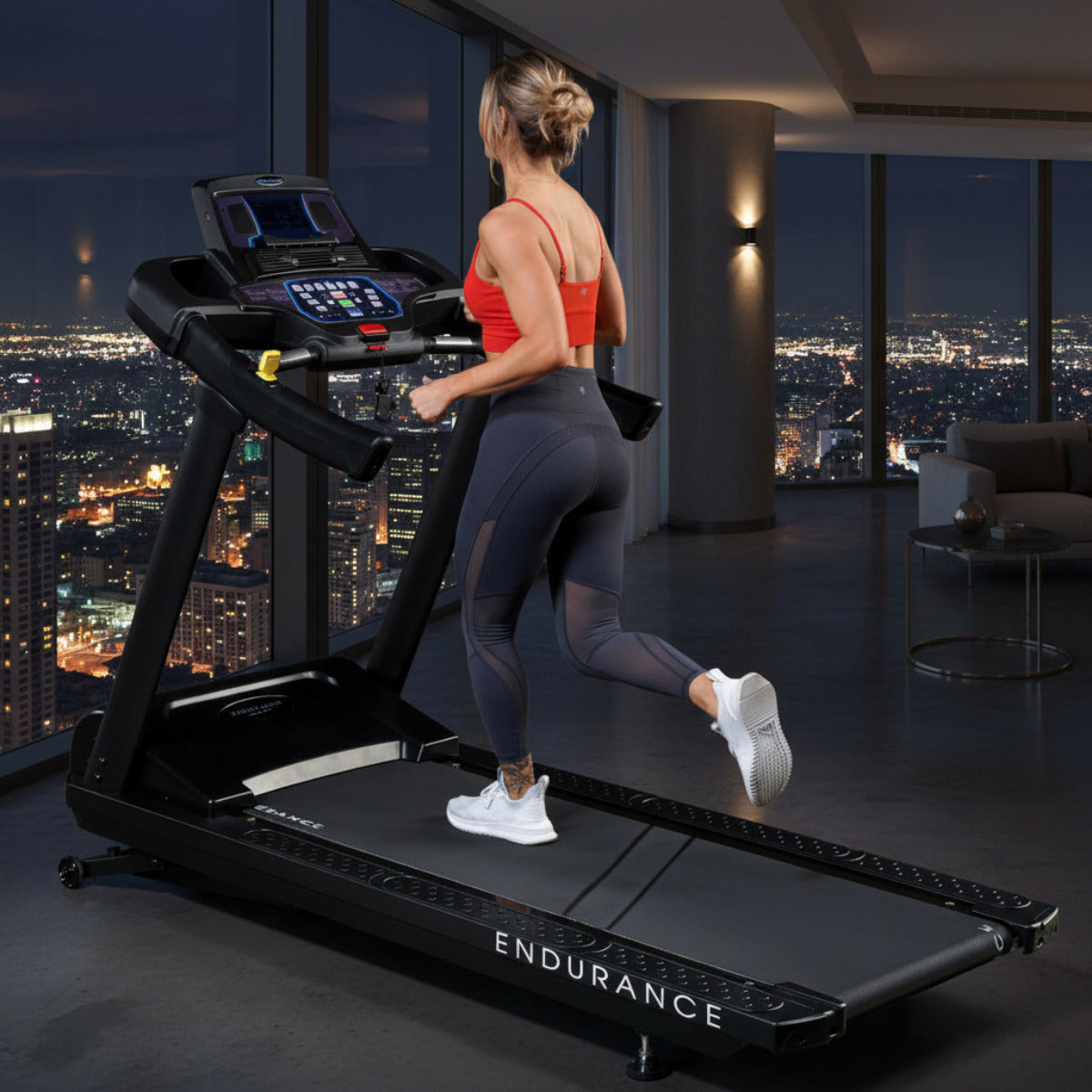 Body-Solid Endurance T150 Commercial Treadmill woman running in penthouse at night
