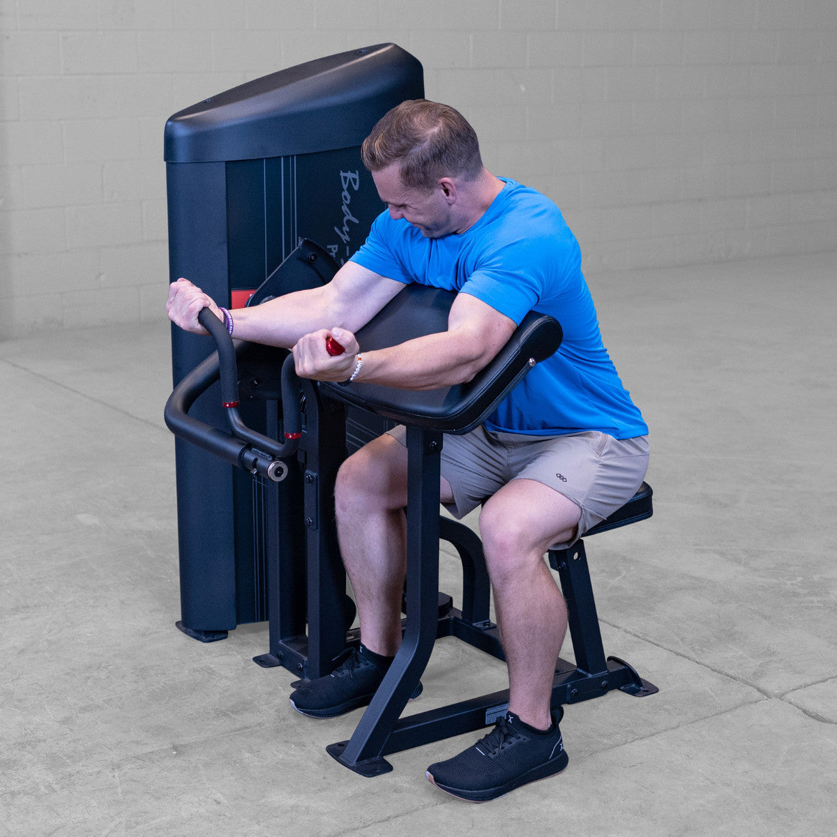 Body-Solid S2ACX Pro ClubLine Series 2 Arm Curl Machine in gym with man exercising