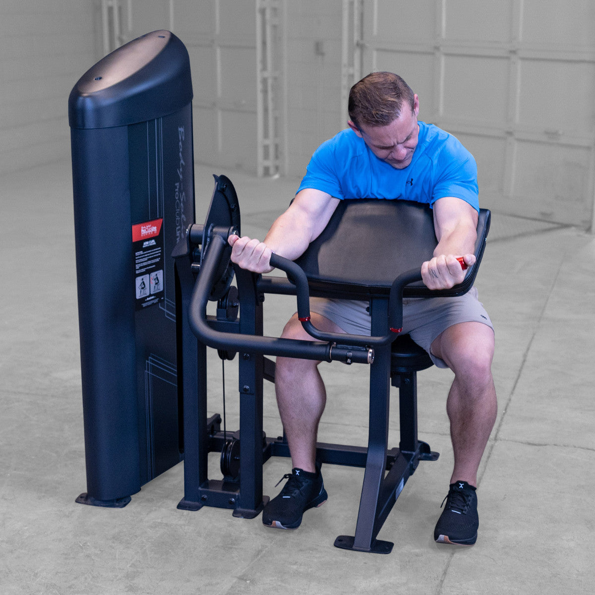 Body-Solid S2ACX Pro ClubLine Series 2 Arm Curl Machine in gym with man exercising