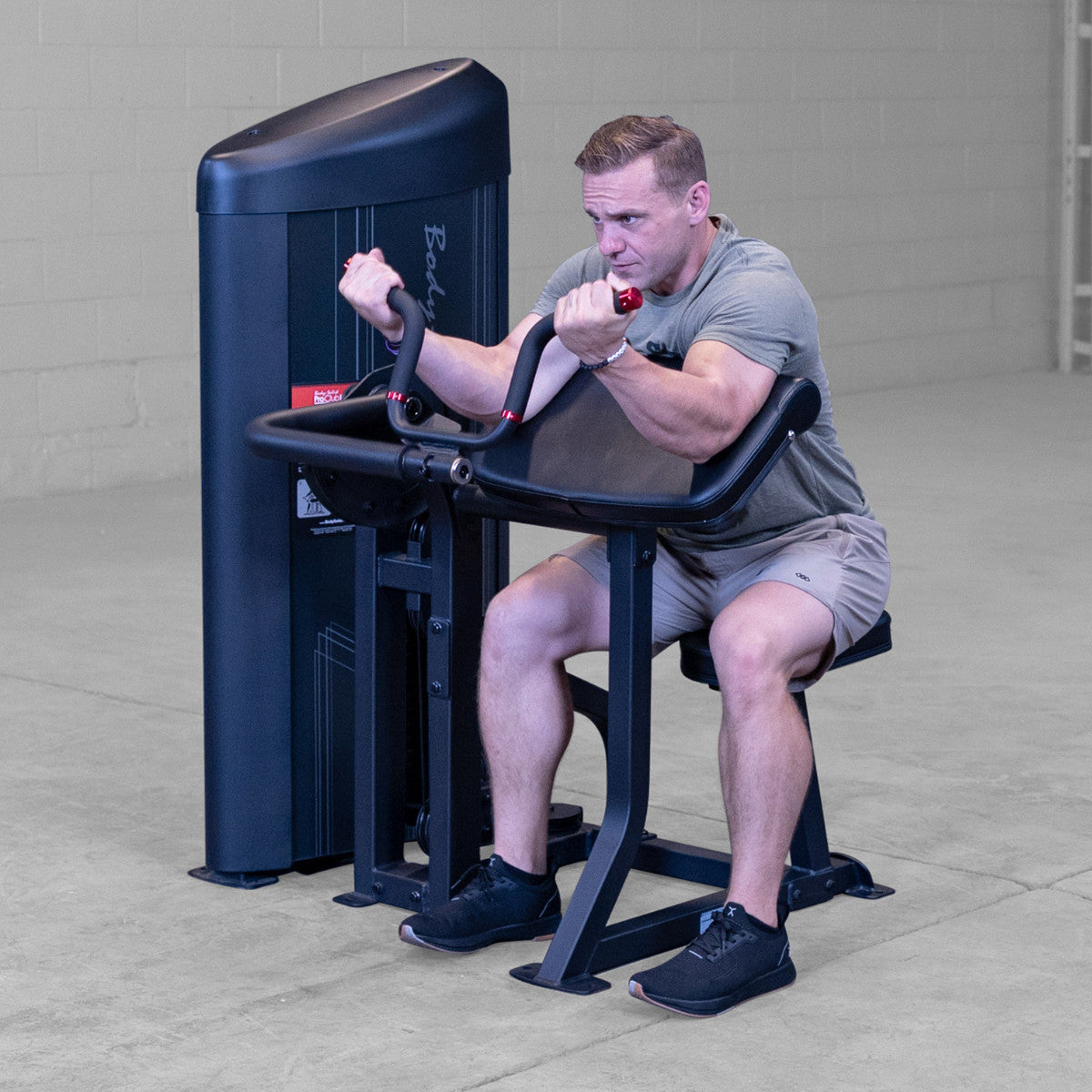 Body-Solid S2ACX Pro ClubLine Series 2 Arm Curl Machine in gym with man exercising