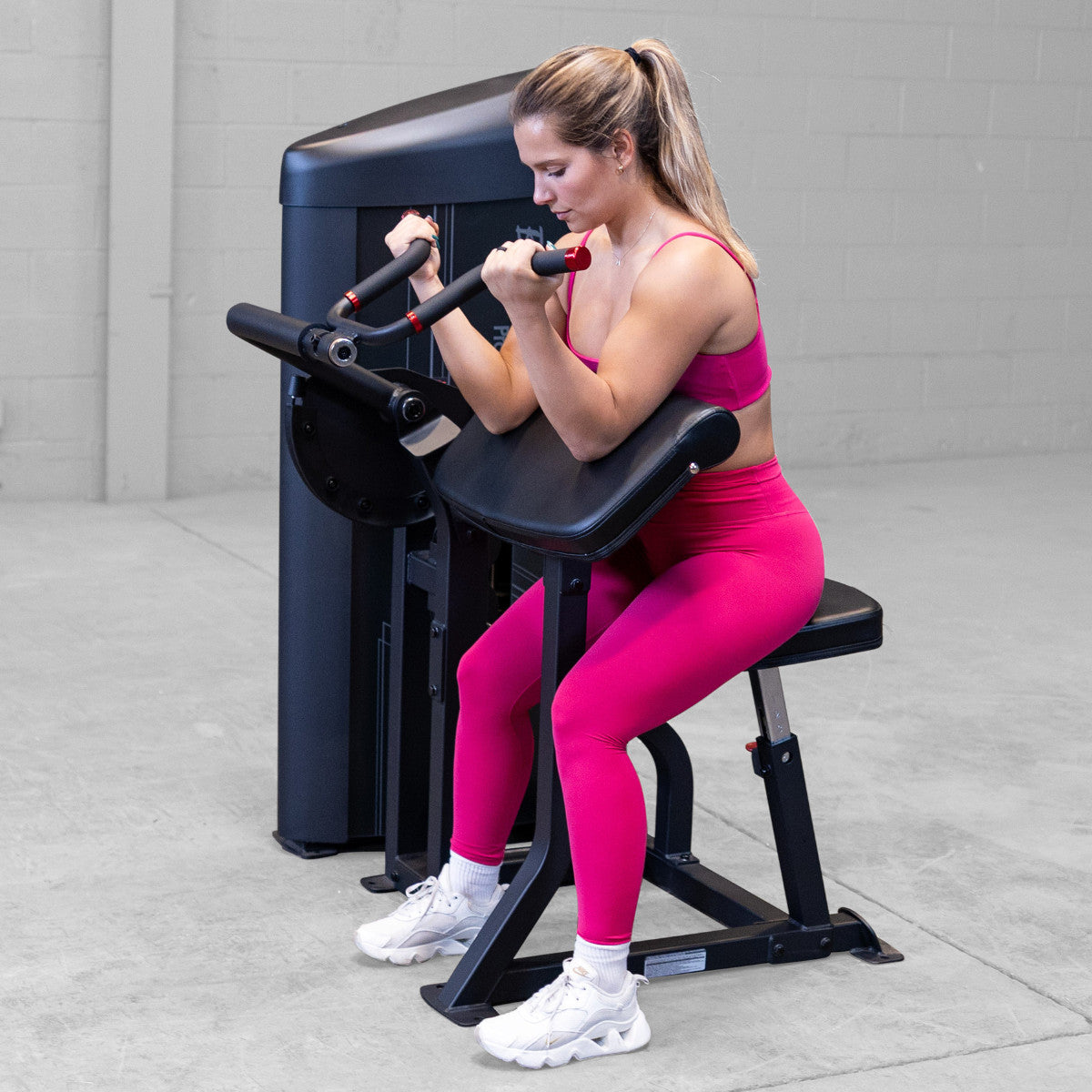 Body-Solid S2ACX Pro ClubLine Series 2 Arm Curl Machine in gym with woman exercising