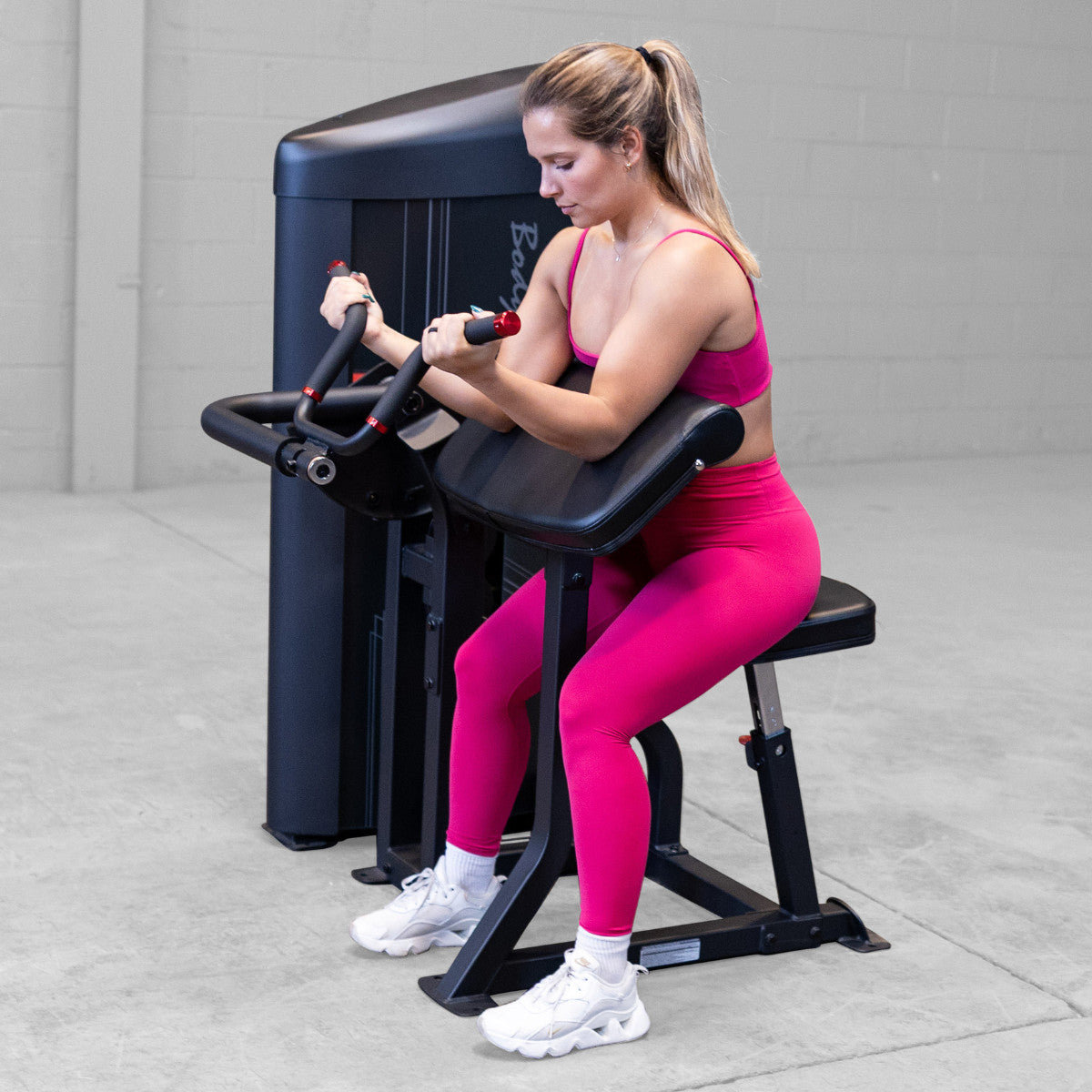 Body-Solid S2ACX Pro ClubLine Series 2 Arm Curl Machine in gym with woman exercising