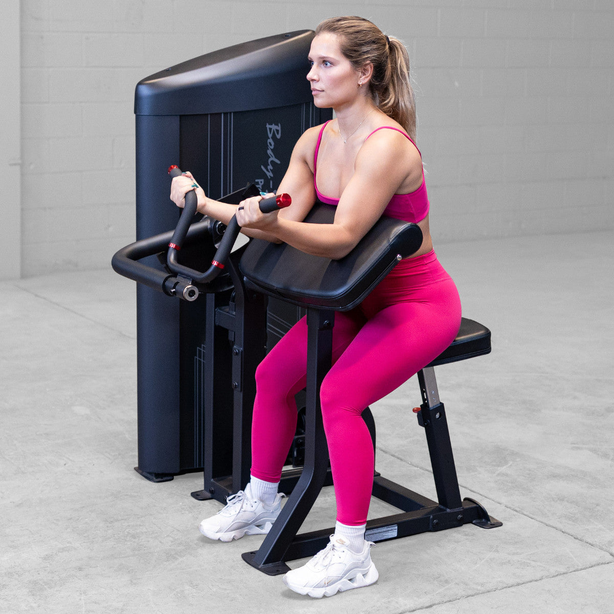 Body-Solid S2ACX Pro ClubLine Series 2 Arm Curl Machine in gym with woman exercising