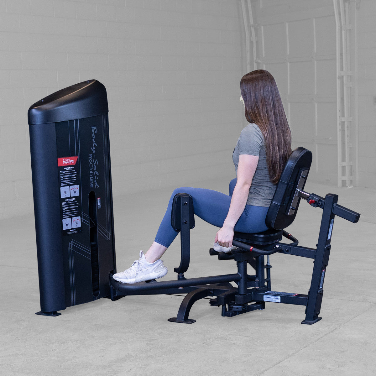 Body-Solid S2IOTX Pro ClubLine Series 2 Dual Inner Outer Thigh Machine in gym with woman exercising
