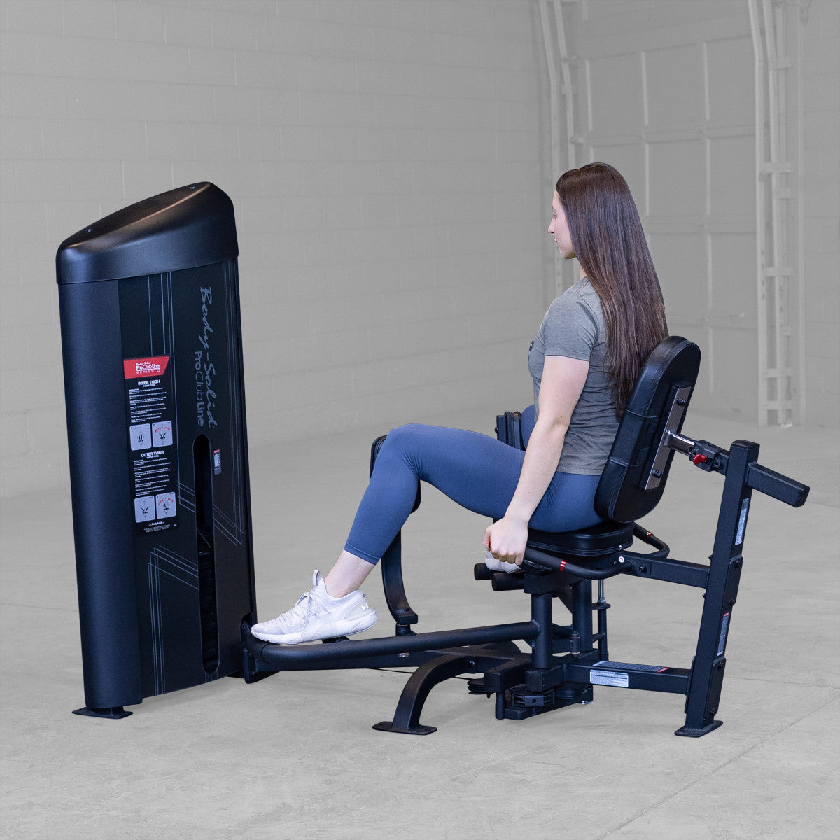 Body-Solid S2IOTX Pro ClubLine Series 2 Dual Inner Outer Thigh Machine in gym with woman exercising
