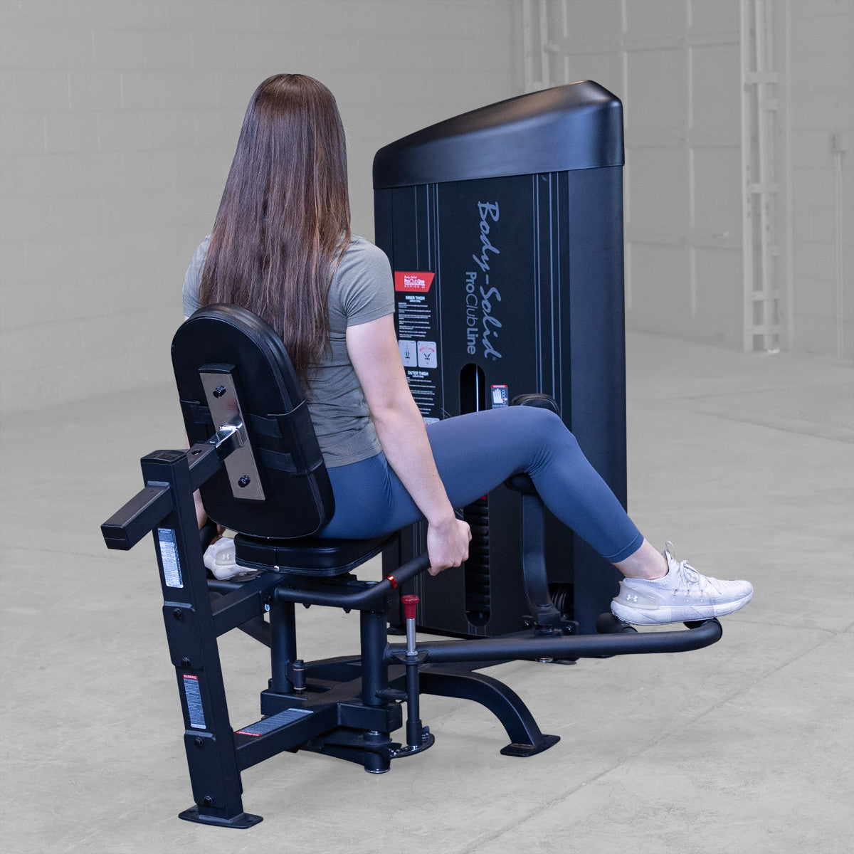 Body-Solid S2IOTX Pro ClubLine Series 2 Dual Inner Outer Thigh Machine in gym with woman exercising