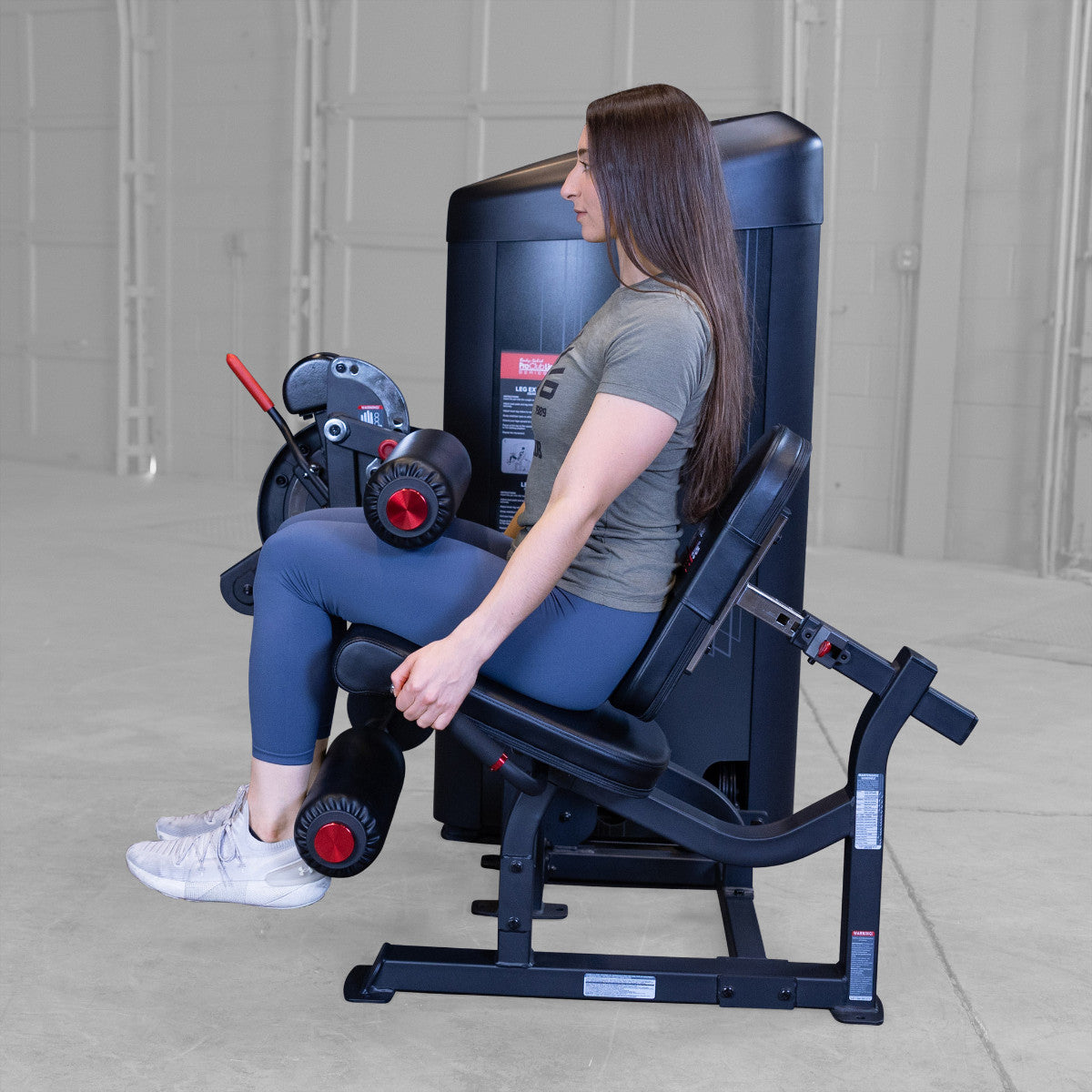 Body-Solid S2LECX Pro ClubLine Series 2 Dual Leg Curl & Extension Machine in gym with woman exercising