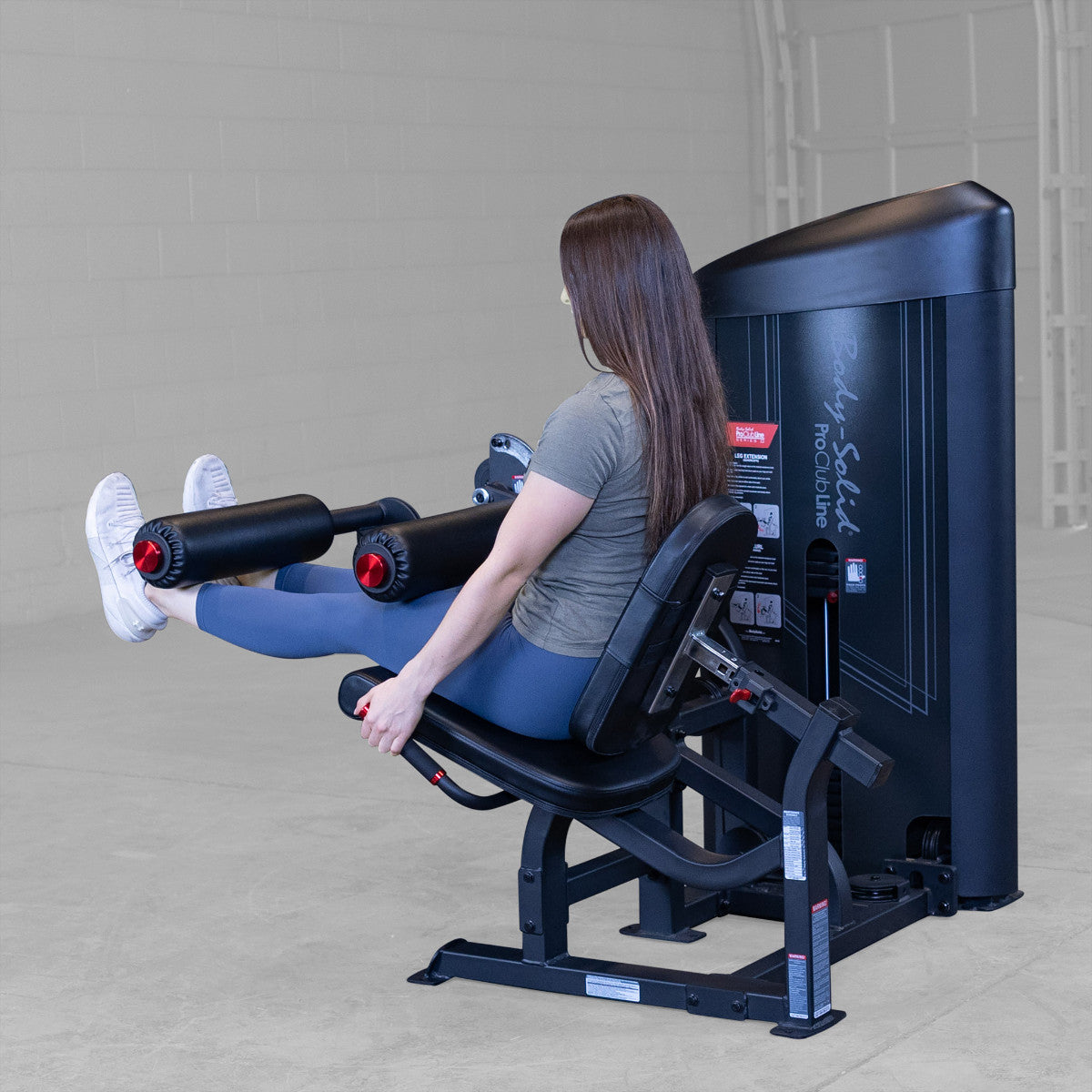 Body-Solid S2LECX Pro ClubLine Series 2 Dual Leg Curl & Extension Machine in gym with woman exercising