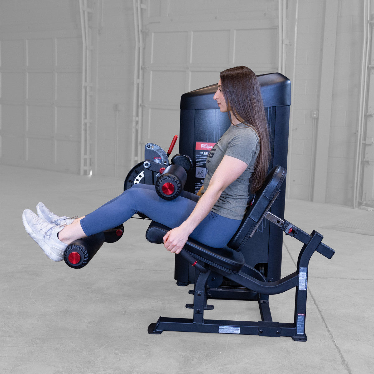 Body-Solid S2LECX Pro ClubLine Series 2 Dual Leg Curl & Extension Machine in gym with woman exercising