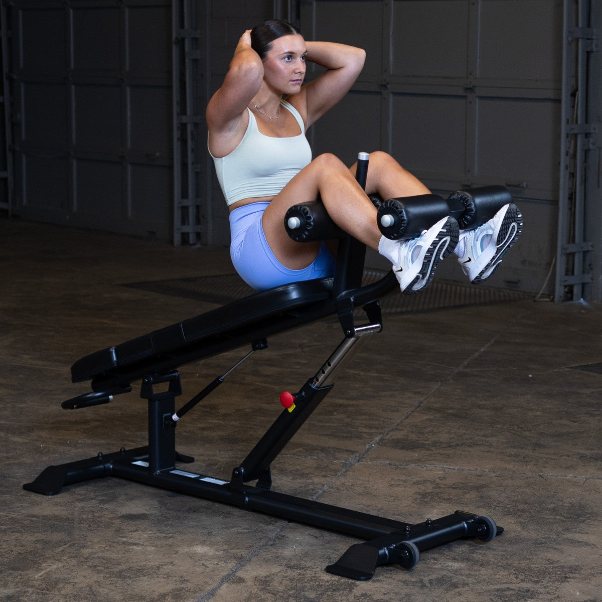 Body-Solid SAB500B Pro ClubLine Adjustable Decline Ab Bench in gym with woman doing ab crunches