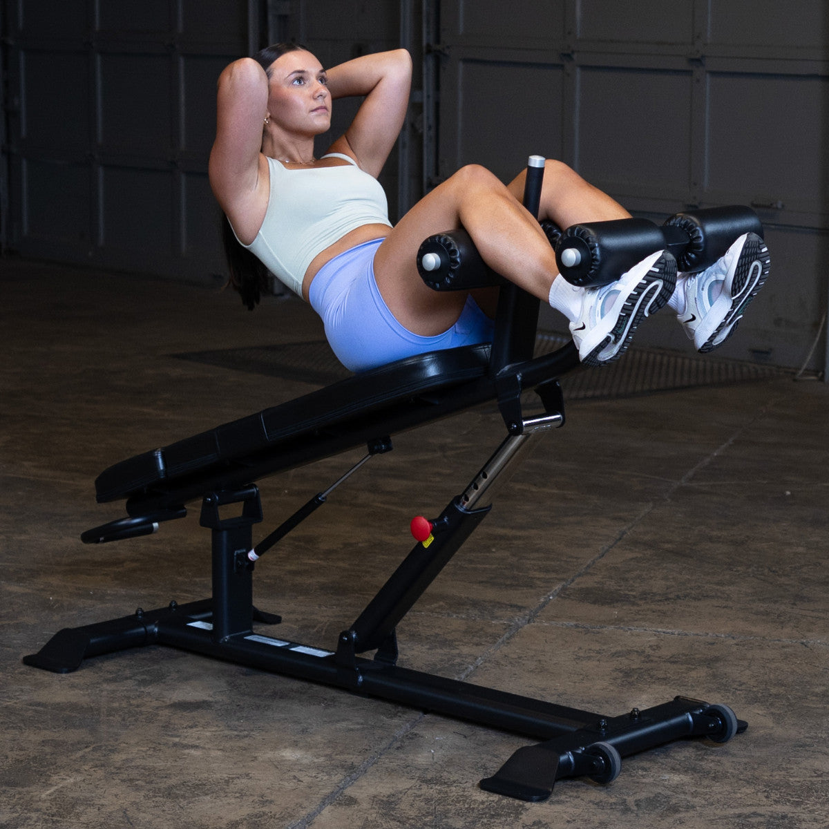 Body-Solid SAB500B Pro ClubLine Adjustable Decline Ab Bench in gym with woman doing ab crunches