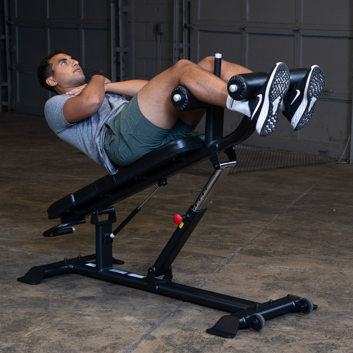 Body-Solid SAB500B Pro ClubLine Adjustable Decline Ab Bench in gym with man doing ab crunches