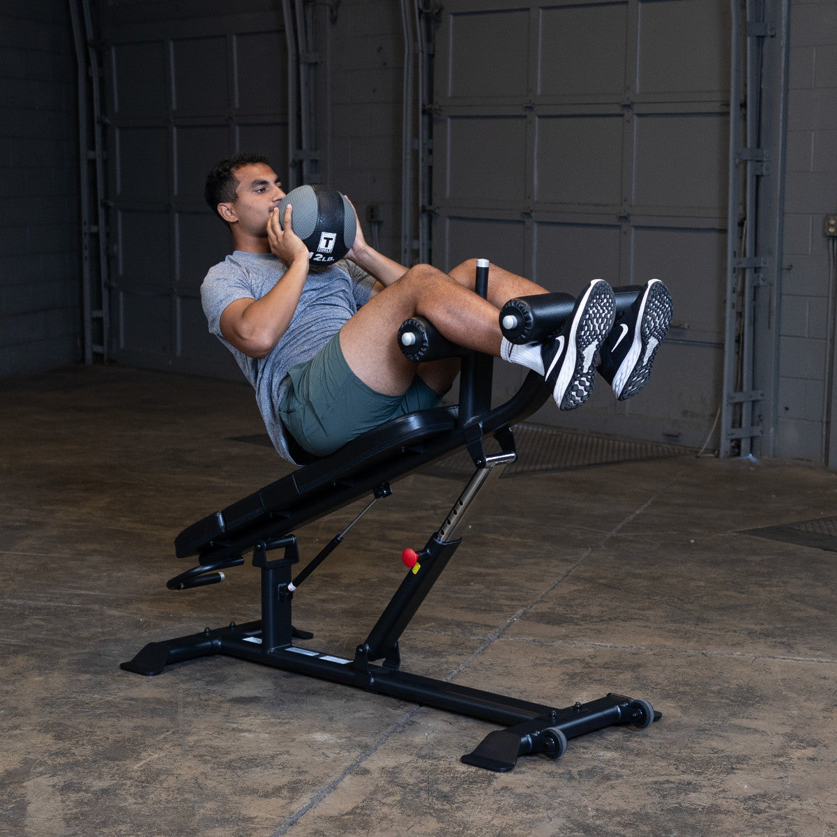 Body-Solid SAB500B Pro ClubLine Adjustable Decline Ab Bench in gym with man doing ab crunches