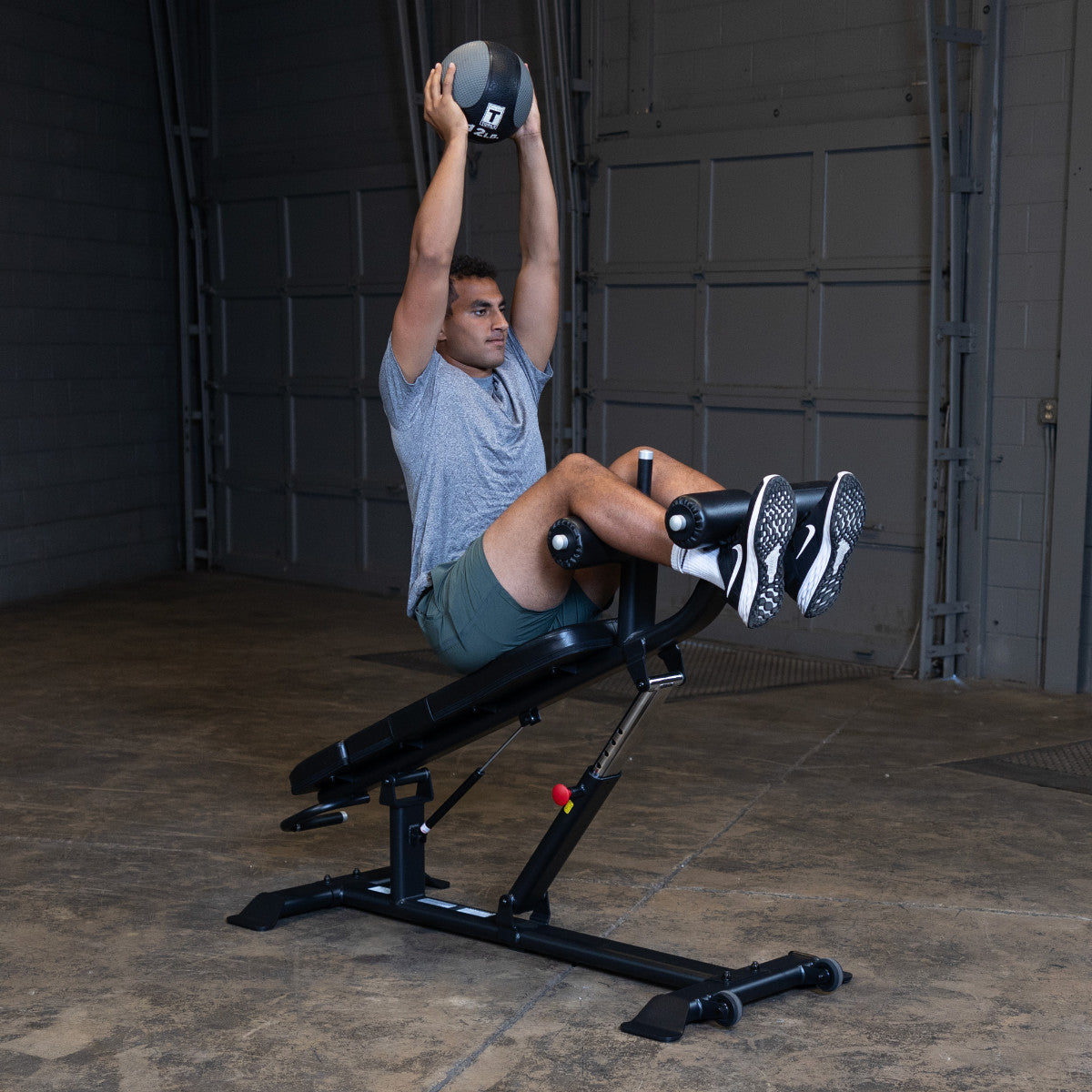 Body-Solid SAB500B Pro ClubLine Adjustable Decline Ab Bench in gym with man doing ab crunches