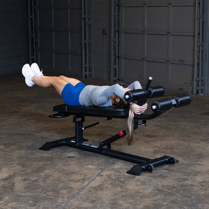 Body-Solid SAB500B Pro ClubLine Adjustable Decline Ab Bench in gym with woman doing leg lifts
