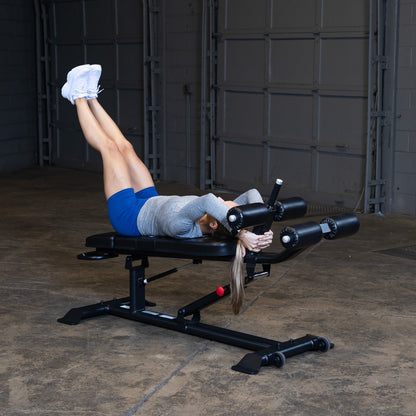 Body-Solid SAB500B Pro ClubLine Adjustable Decline Ab Bench in gym with woman doing leg lifts