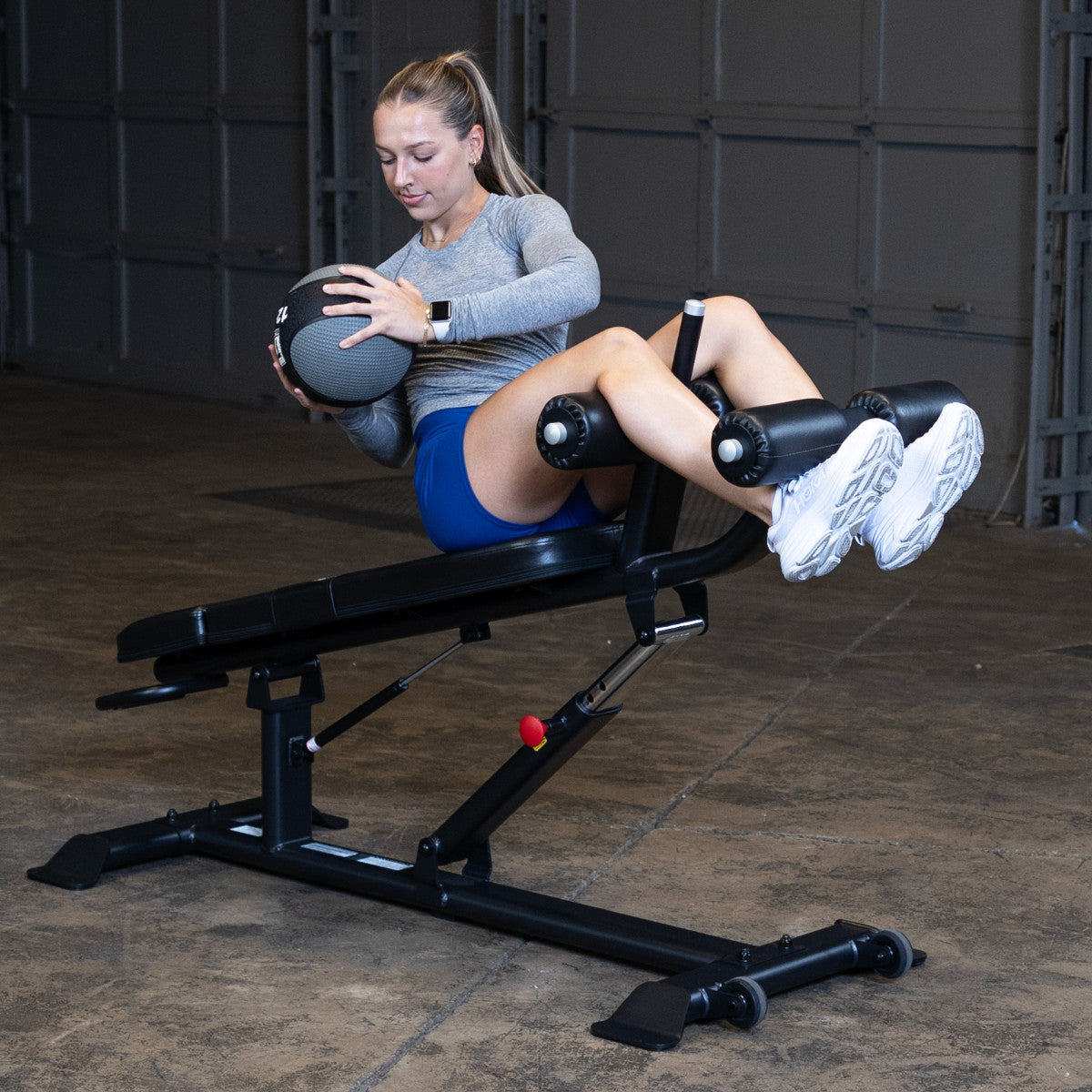 Body-Solid SAB500B Pro ClubLine Adjustable Decline Ab Bench in gym with woman doing ab crunches