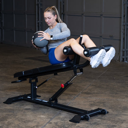 Body-Solid SAB500B Pro ClubLine Adjustable Decline Ab Bench in gym with woman doing ab crunches