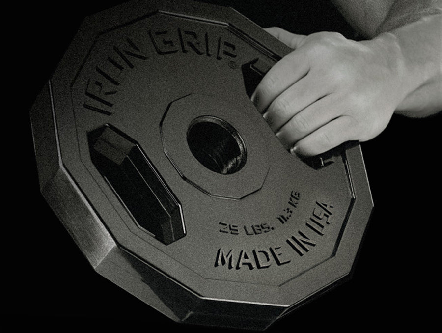Man gripping Iron Grip Urethane Encased Olympic Plate.