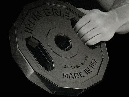 Man gripping Iron Grip Urethane Encased Olympic Plate.