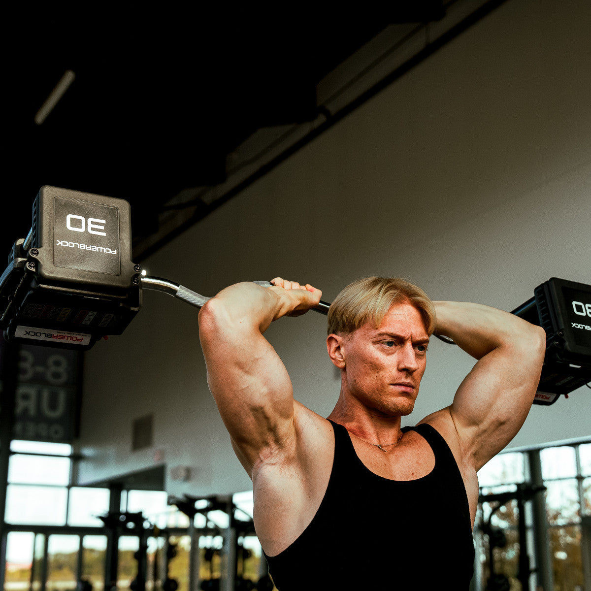PowerBlock Pro 100 EXP EZ Curl Barbell tricep overhead curl exercise.