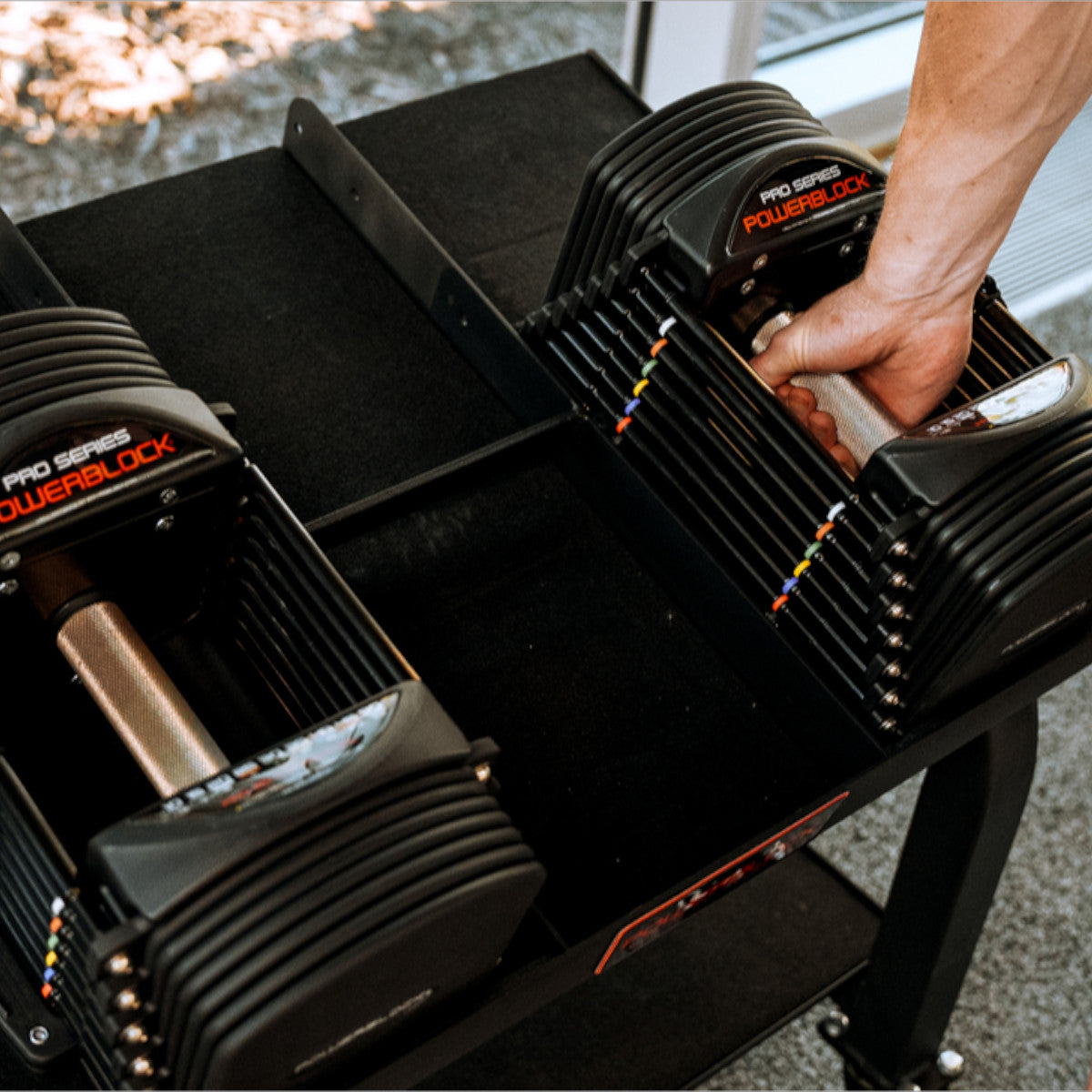 Person using a PowerBlock Commercial Pro 50 set with a focus on the equipment.