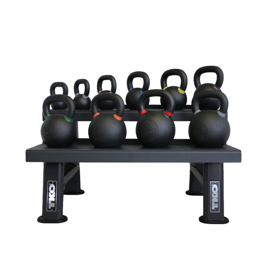 Set of TKO kettlebells on a black TKO weight rack against a white background